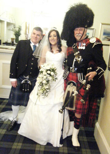Laura and Paul with James A Nicholl Scottish Piper at their wedding at Strathblaine Country House Hotel